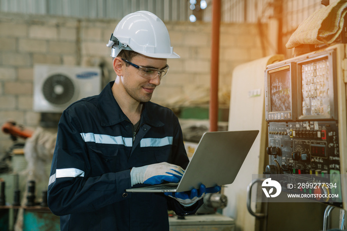 Engineers using laptop checking and repair pressing metal machine at factory, Machine maintenance technician operation concept.