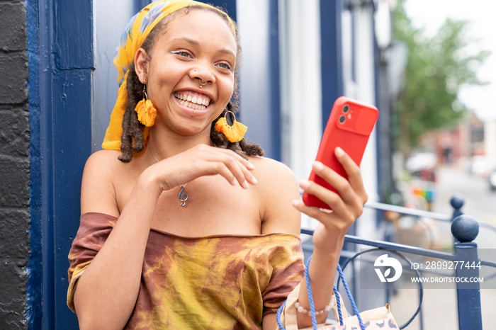 Portrait of smiling woman with smart phone in city