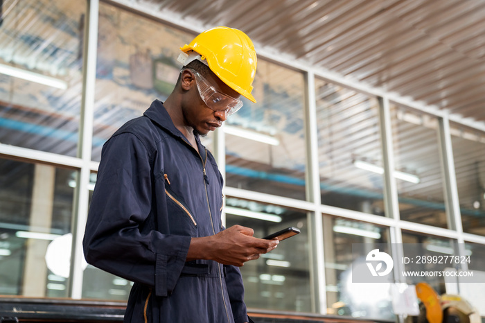 Manufacturing worker. Worker controlling the work. Factory technician using mobile phone.