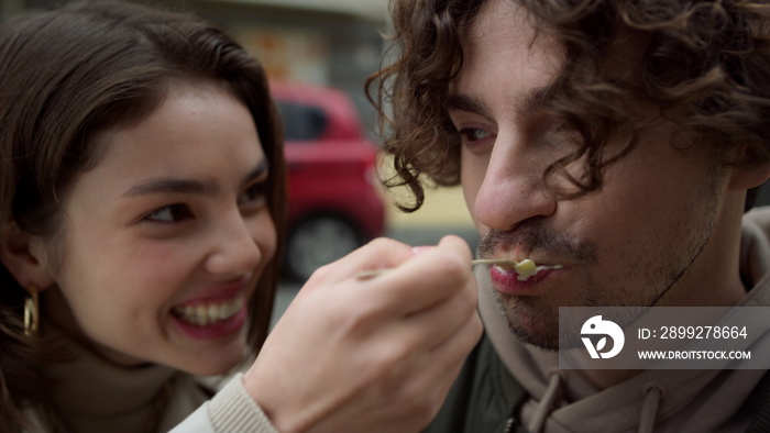 Happy couple having fun on city street. Cheerful pair fooling on date outdoor.