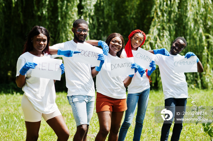 Group of happy african volunteers hold blank board in park. Africa volunteering, charity, people and ecology concept.