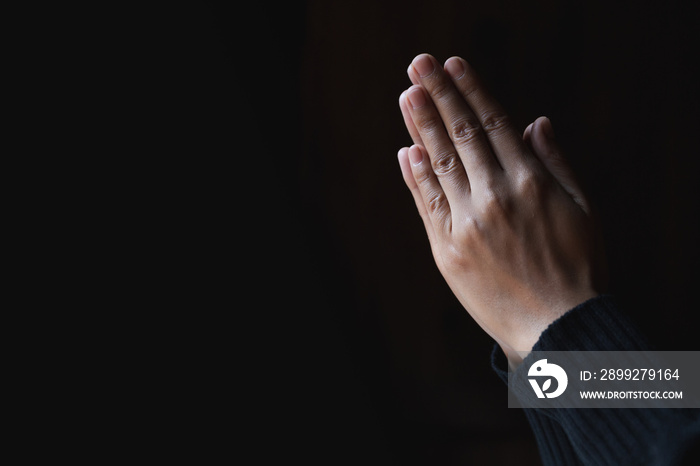 Praying hands with faith in religion and belief in God on dark background. Pay respect.  Namaste or Namaskar hands gesture.