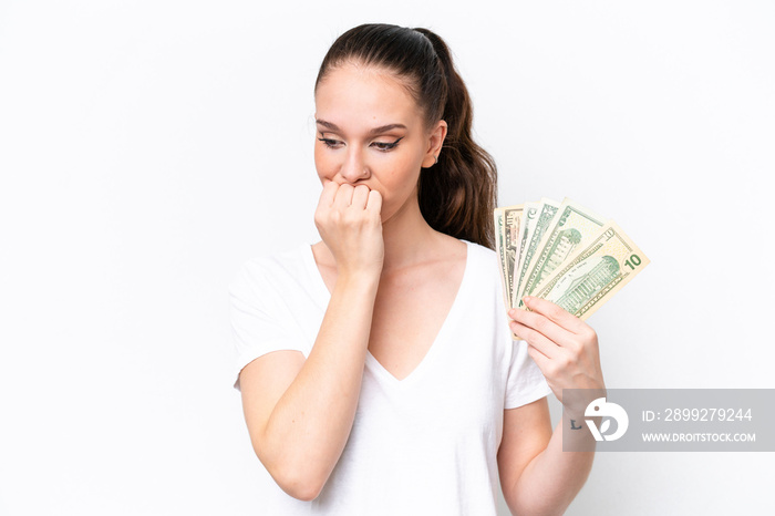 Young caucasian woman taking a lot of money isolated on white background having doubts