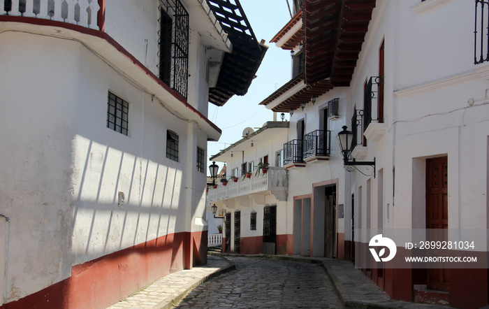 view of streets and traditional facades, houses with door, windows and tile roof in Cuetzalan Puebla Mexico