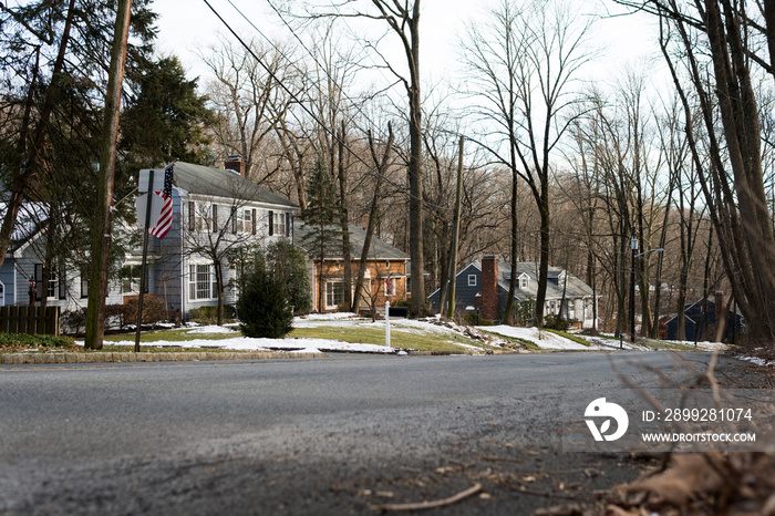 Classic architecture houses by Glenside Ave in Scotch Plains, New Jersey. Next to Watchung Reservation. Empty street; no people, no traffic. Cloudy day in winter, Trees without leaves.