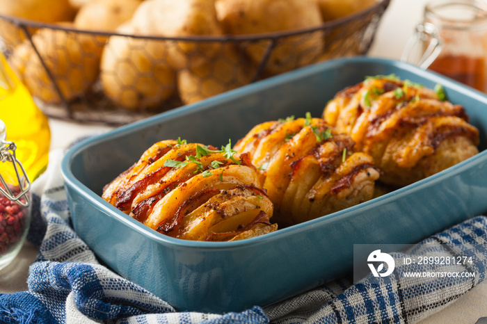 Baked potatoes in Swedish. Hasselback. Stuffed with cheese and bacon. Top view.