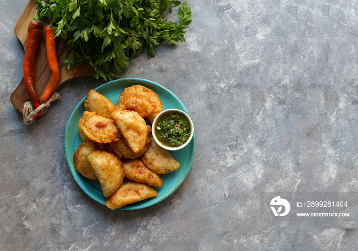 Latin American fried empanadas with  sauce. Top view.