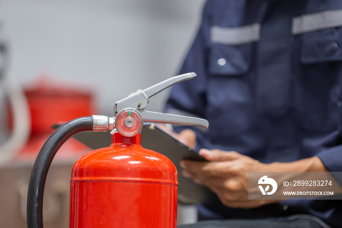 Engineer are checking and inspection a fire extinguishers tank in the fire control room for safety training and fire prevention.