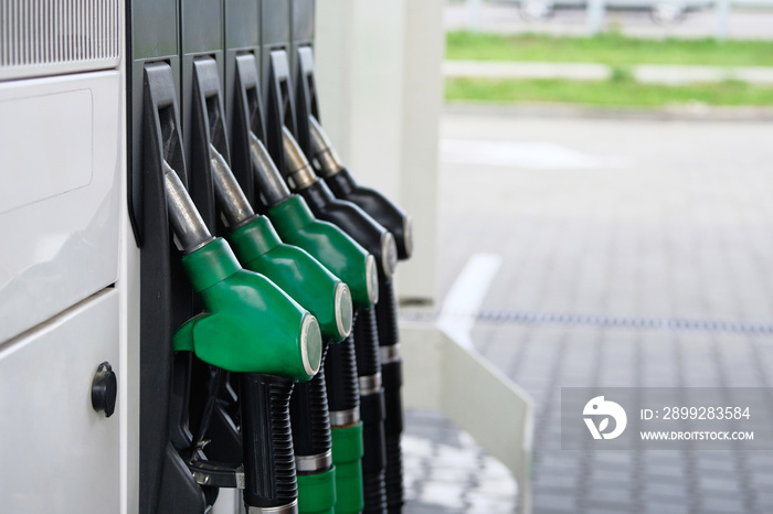 Green and black fuel pistols on fuel station. Gas station and petroling concept. Pumping gas at gas pump.