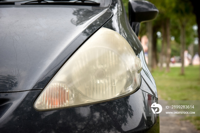 Damaged and blurred headlight surface as a result of weather con