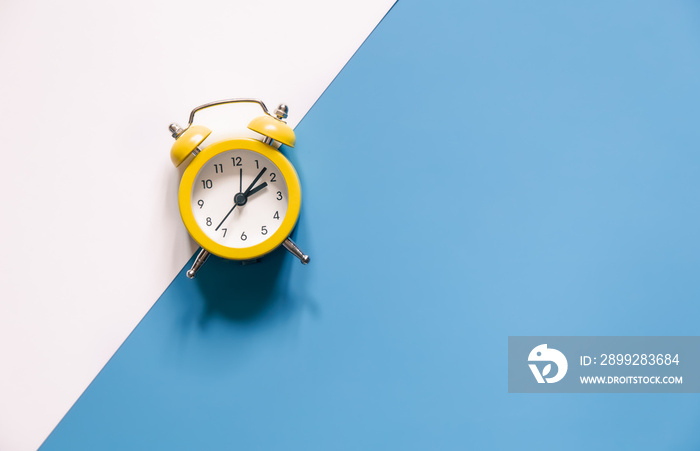 Yellow alarm clock on colored background isolated, flat lay.