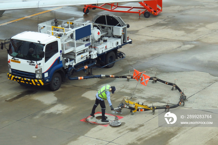 Refuel truck for airplane parked and waiting refuel the airplane on ground in the airport.Ground technician worker refill passenger airplane gasoline fuel from mobile station into an airplane wing