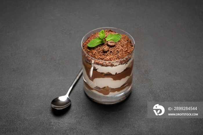 portion of Classic tiramisu dessert in a glass on concrete background