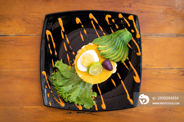 Traditional Peruvian dish called Causa Limeña made with mashed potatoes, vegetables, avocado and eggs