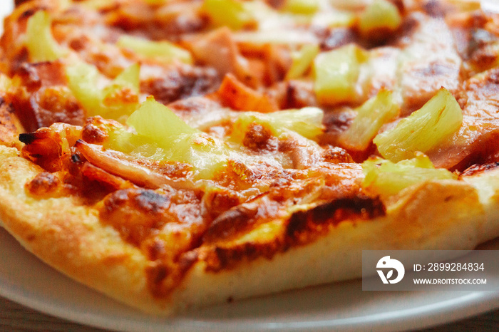 Close up of Pizza with pineapple,  mozzarella cheese, ham, bacon, pizza sauce. Sliced Hawaiian pizza texture,