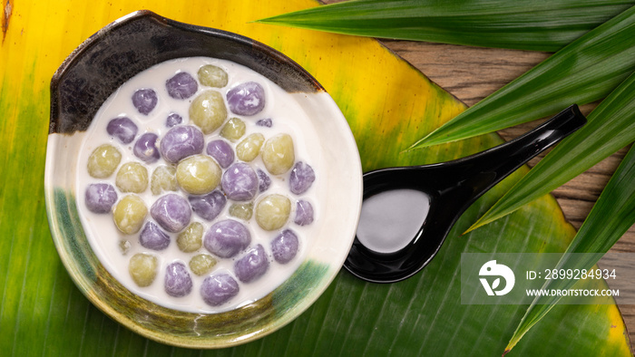 Bualoy, Bua Loy, Bualoi, Bua Loi, Thai dessert, sticky rice dumplings in sweet coconut milk, purple color from taro, green color from pandan leaf on banana leaf, top view, full HD ratio