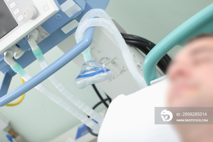 Respiratory equipment on the background of sleeping patient in the hospital bed