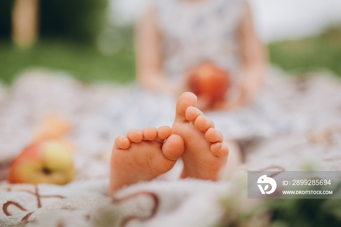 Children’s feet close up on the street in the park. Blurred background with bokeh. Baby’s toes