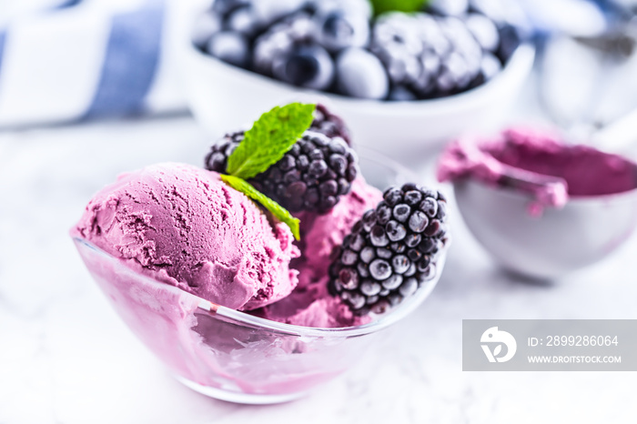 Blueberry and blackberry ice cream in bowl with frozen fruits