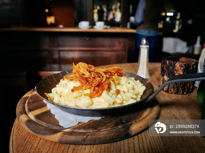 Käsespätzle in einer Pfanne aus Eisen im Wirtshaus Biergarten Restaurant