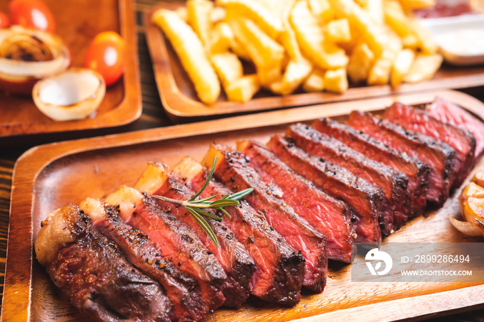 Beef steak serve on wooden plate with rosemary herb and pepper, fresh grilled meat food made for dinner, picanha or sirloin beef fillet cut with salt and vegetable