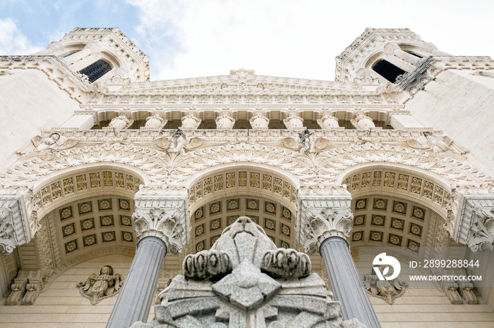 White stone facade of the Basilica of Notre-Dame de Fourvière in Lyon, France.