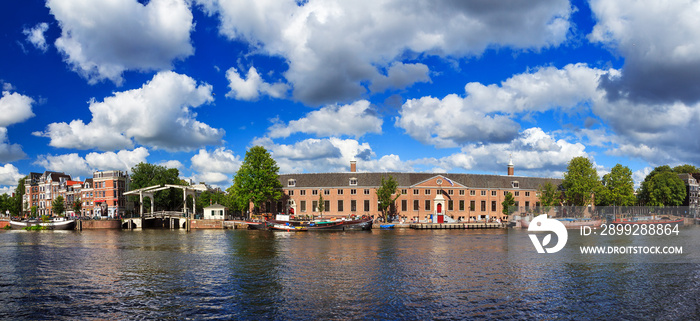 Beautiful panoramic panorama of museum the Hermitage at the river Amstel in Amsterdam, the Netherlands, on a sunny summer day with clouds