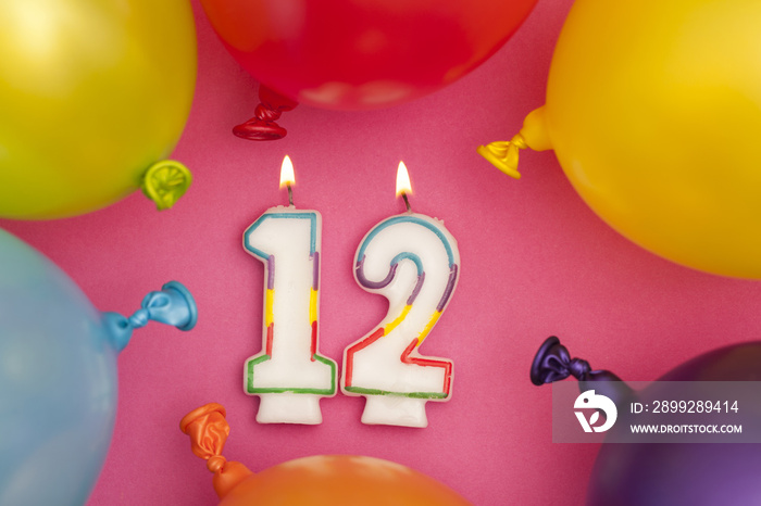 Happy Birthday number 12 celebration candle with colorful balloons