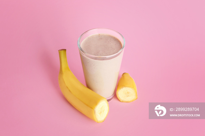 Glass of tasty banana smoothie on color background