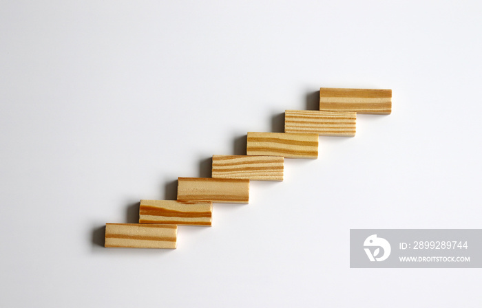 Seven wooden blocks stacked in the shape of a staircase.