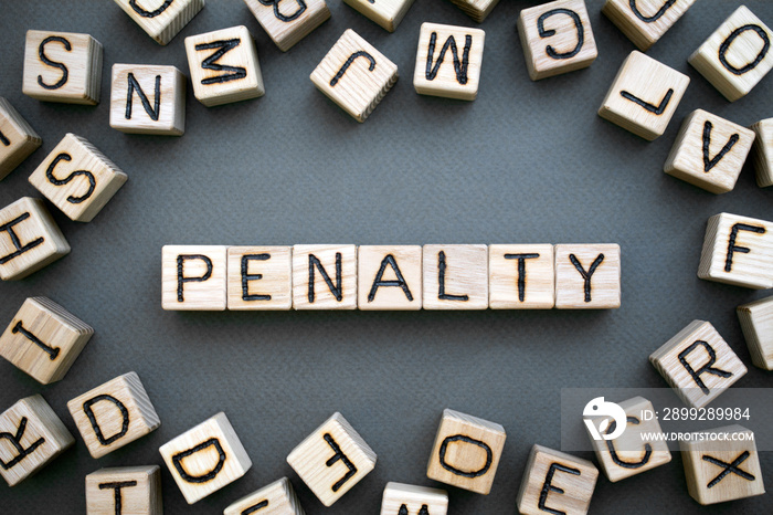 the word penalty wooden cubes with burnt letters, penalty for tax evasion, gray background top view, scattered cubes around random letters