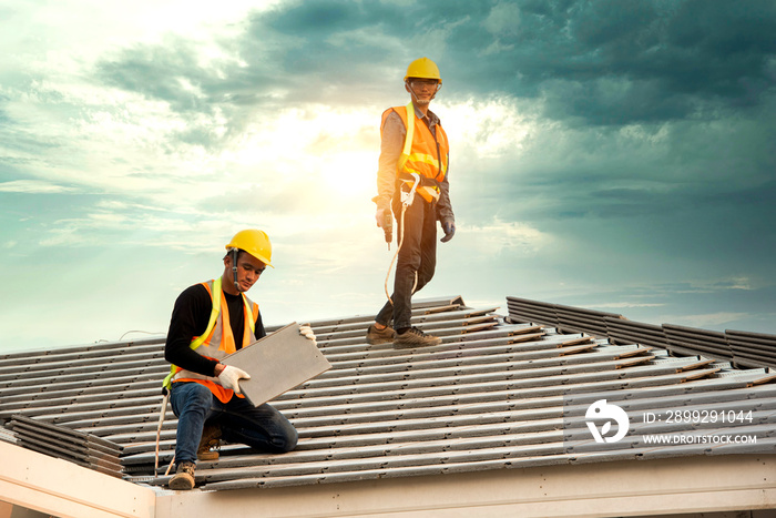 Asian engineer workers install new CPAC roof, roofing tools, electric drill, use on new roof with CPAC roof house construction idea.