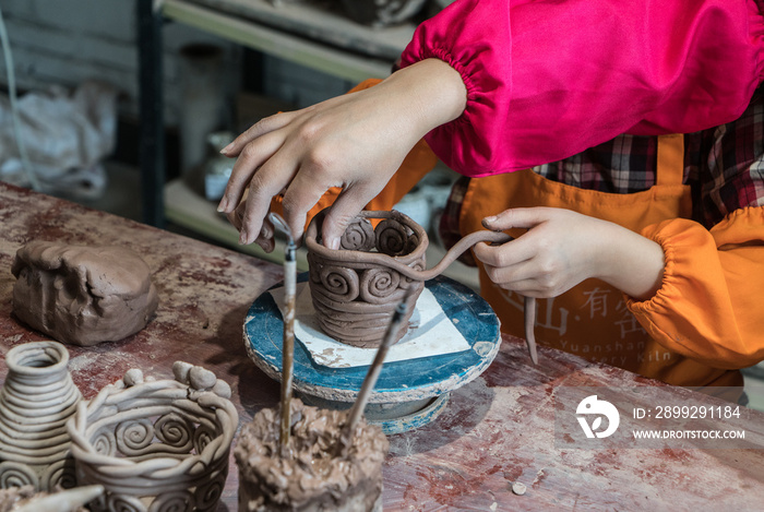 hands of a potter, creating an earthen jar on the circle