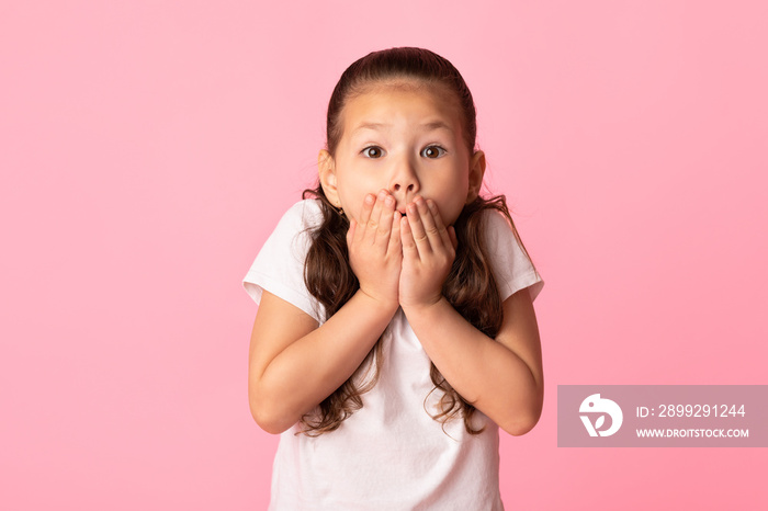 Portrait of amazed asian girl covering her mouth with hands