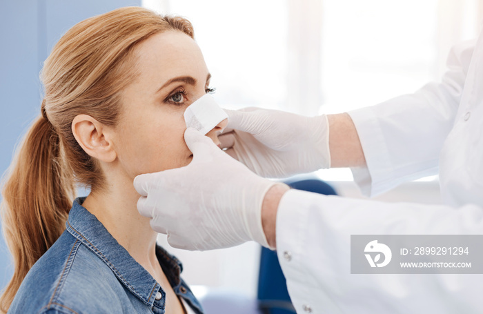 Nice male doctor putting a medical dressing