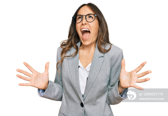 Young brunette woman wearing business clothes crazy and mad shouting and yelling with aggressive expression and arms raised. frustration concept.