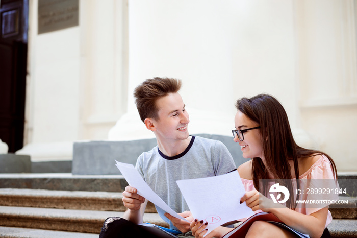 Happy university students share results of final test. Both have received the highest mark for their examination