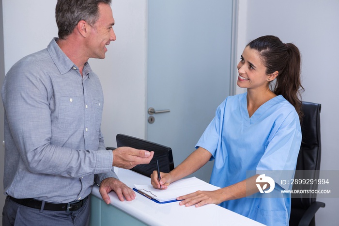 Smiling doctor and patient talking at desk