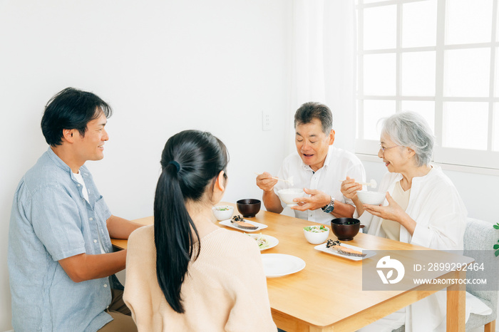 楽しい食事をする老夫婦と若い夫婦（笑顔）