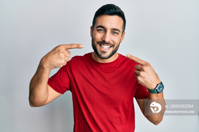 Young hispanic man wearing casual clothes smiling cheerful showing and pointing with fingers teeth and mouth. dental health concept.