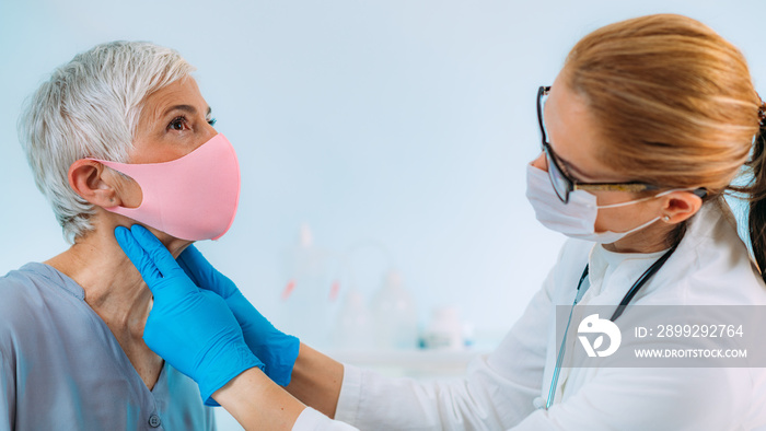 Thyroid Gland Control. Doctor Examining Senior Woman at Clinic.