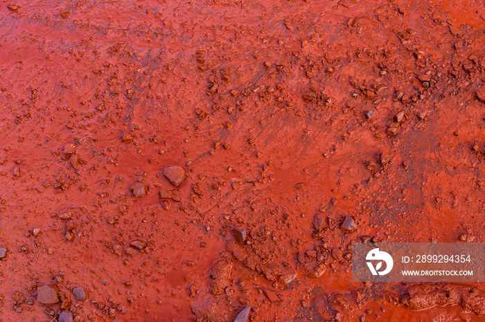 Background of red dirt road polluted with the iron ore. Environmental pollution