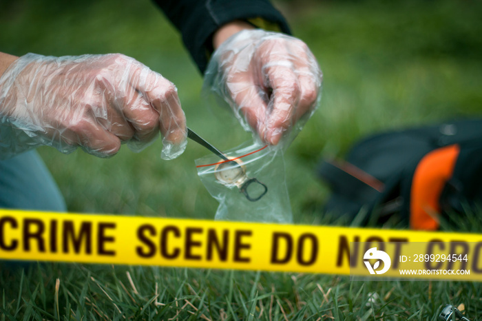 Crime scene expert collecting evidence at the murder location. Law and police concept. Selective focus