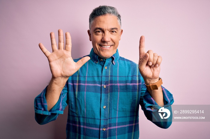 Middle age handsome grey-haired man wearing casual shirt over isolated pink background showing and pointing up with fingers number six while smiling confident and happy.