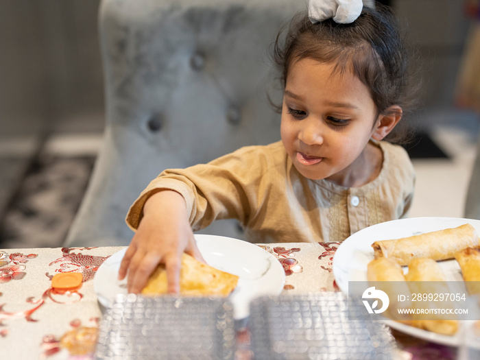 Boy (2-3) putting food on plate