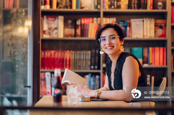 Woman reading a book while relaxing in the cafe or a bookstore