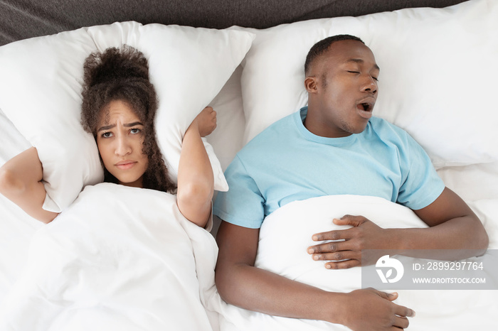 Snoring man sleeping with apnea and sleepless woman, angry wife unable to get to sleep