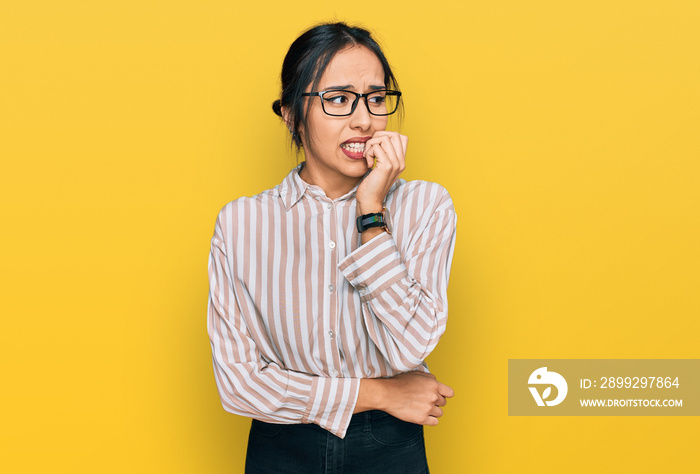 Young hispanic girl wearing casual clothes and glasses looking stressed and nervous with hands on mouth biting nails. anxiety problem.