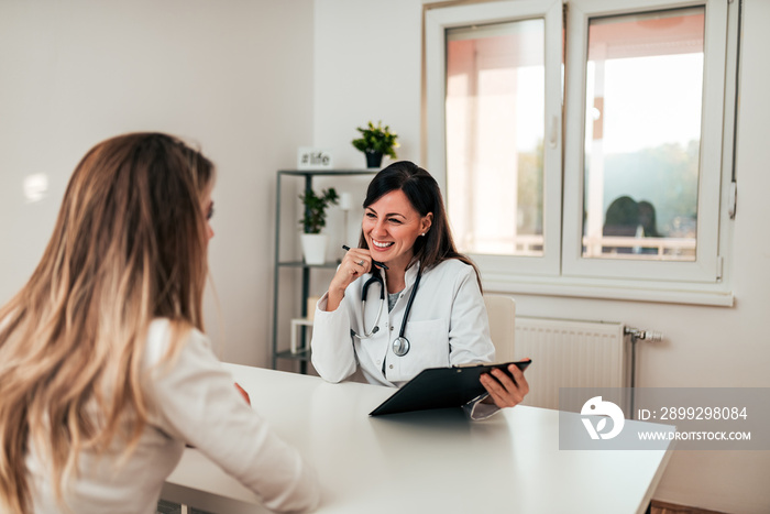 Beautiful doctor and young patient talking in the doctors’s office.