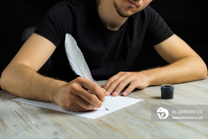 Male hand with a goose feather. Poetry and journalism symbol. The concept of writing texts.